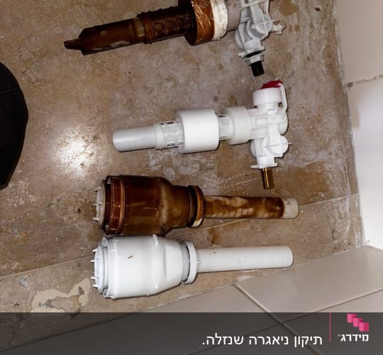 חלקי אינסטלציה על רצפה, כולל שסתומים וצינורות